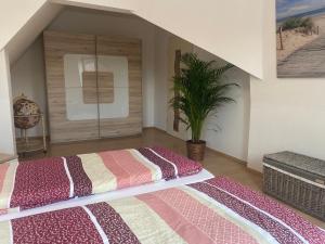 a bedroom with a large bed and a plant at Ferienwohnung Bernsteinsucher städtische Bestlage in Ribnitz-Damgarten