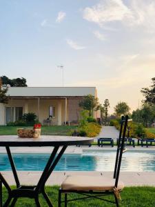 a table and a chair in front of a pool at Le stanze di chiara in Torre Lapillo