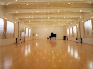 a large hall with a piano in the middle at Park Lodge Sekine in Myoko