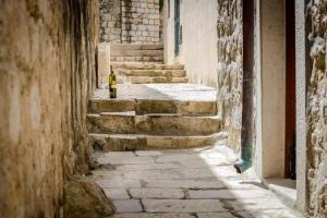 un vicolo con scale e una bottiglia di vino di Apartment Sympa a Dubrovnik