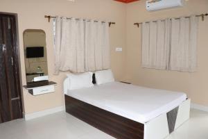 sypialnia z dużym łóżkiem i lustrem w obiekcie Somani Inn w mieście Jhārgrām