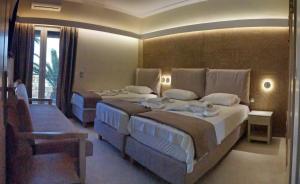 um quarto de hotel com duas camas e um sofá em Galazio Asteri I em Loutrópolis Thermís