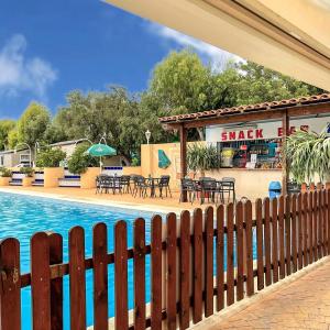 a fence next to a swimming pool with a restaurant at Camping Costa Blanca in El Campello