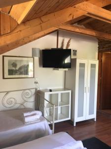 a bedroom with two beds and a tv on the wall at Bochtis Acrogiali in Ammoudia