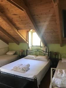 two beds in a room with wooden ceilings at Bochtis Acrogiali in Ammoudia