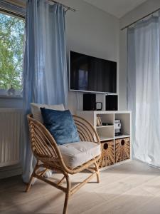 einen Korbstuhl mit einem blauen Kissen im Wohnzimmer in der Unterkunft Apartament Azzurro in Międzywodzie