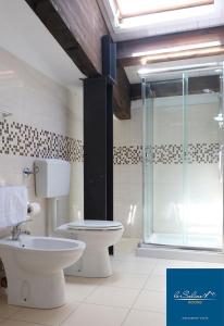 uma casa de banho com um WC e uma cabina de duche em vidro. em Le Saline Rooms Marzamemi em Marzamemi