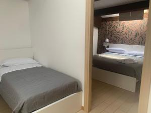 a small bedroom with a bed and a mirror at Le Saline Rooms Marzamemi in Marzamemi