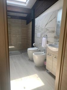a bathroom with a tub and a toilet and a sink at Le Saline Rooms Marzamemi in Marzamemi