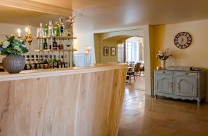 un bar en una habitación con una mesa con botellas de vino en Logis Relais de la Source, en Saint-Seine-lʼAbbaye