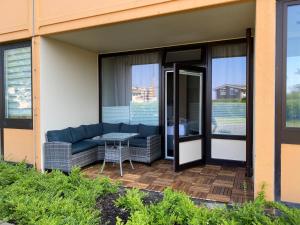 a screened in porch with a couch and a table at Ferienwohnung Ostseeglück in Wendtorf