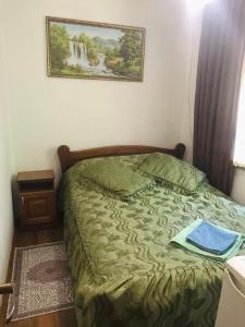 a bed in a bedroom with a picture on the wall at Підскельний in Yaremche