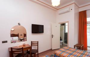 1 dormitorio con cama, mesa y espejo en Hôtel Astrid en Casablanca