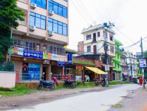 a street with buildings and motorcycles parked on the side of a road at Hotel Om in Kathmandu