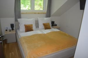 a bedroom with a large bed with white sheets and pillows at Domek nad Kryniczanką in Krynica Zdrój