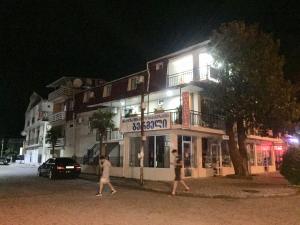 two people walking in front of a building at night at Magnolia Guest House in K'obulet'i +16 photos