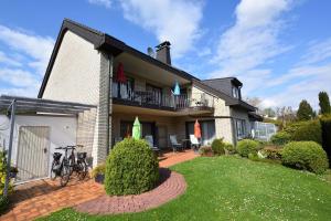 uma casa com uma varanda e um quintal em Haus Wegener em Bad Sassendorf