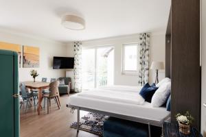 1 dormitorio con 1 cama grande y comedor en HOMEBOUND APARTMENTS Salzburg City II - contactless check-in, en Salzburgo