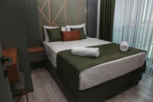 a bedroom with a large bed with towels on it at Güven Park Residance & Apart Hotel in Kemer +56 photos