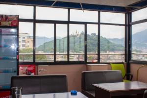 a restaurant with tables and chairs and a large window at Hotel Om in Kathmandu +20 photos