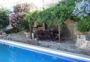 un patio con mesa y sillas junto a una piscina en Casa Jazmin, en Roses