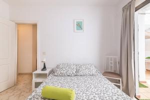 a white bedroom with a bed and a chair at alquilaencanarias El Medano Playa El Cabezo in El Médano