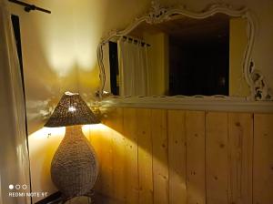 una lámpara sentada en una mesa frente a un espejo en Hotel Garisenda B&B - in Centro a Riccione -, en Riccione