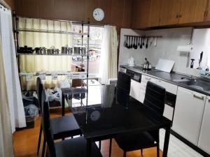 a kitchen with a black table and chairs in a kitchen at コンドミニアム津和野荘 in Tsuwano