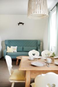 ein Wohnzimmer mit einem Tisch und einem blauen Sofa in der Unterkunft HOMEBOUND APARTMENTS Salzburg City II - contactless check-in in Salzburg