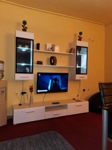 ein Wohnzimmer mit einem TV auf einem weißen Entertainment-Center in der Unterkunft Apartman Nik-Rom in Bosanska Gradiška