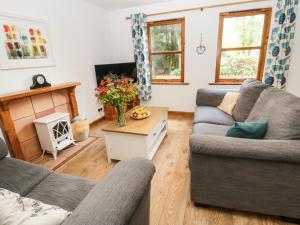 a living room with two couches and a tv at Gardener's Cottage in Allanton