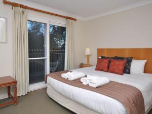a bedroom with a large bed with towels on it at Villa 3br Vista Villa located within Cypress Lakes Resort in Pokolbin