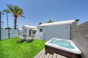 a backyard with a hot tub on a lawn at Club Maspalomas Suites & Spa - Adults Only in Maspalomas