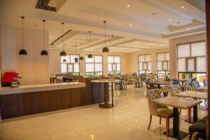 a restaurant with tables and chairs and a bar at Virunga Inn Resort & Spa in Kinigi