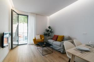 ein Wohnzimmer mit einem Sofa und einem Tisch in der Unterkunft El Naranjito de Triana in Sevilla