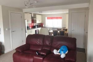 a brown couch with a stuffed animal on it in a kitchen at Beautiful Sea view, Entire 2 bed Apartment, Portrush centre West Strand BeachView in Portrush