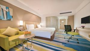 a hotel room with a bed and a couch at Holiday Inn Express Hangzhou Gongshu by IHG in Hangzhou