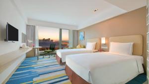 a hotel room with two beds and a television at Holiday Inn Express Hangzhou Gongshu by IHG in Hangzhou +31 photos