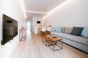 een woonkamer met een bank en een tv bij El Naranjito de Triana in Sevilla
