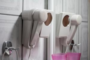 a row of hair dryers on a wall with cups at Hotel Maria in Skala Potamias +24 photos