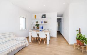 ein weißes Zimmer mit einem Tisch, Stühlen und einem Bett in der Unterkunft Precioso apartamento en primera línea de mar en Calella de Palafrugell in Calella de Palafrugell