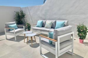 a patio with two chairs and a couch and a table at CASA PISCINA DOCTOR FLEMING 51 in Llubí