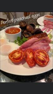 um prato de alimentos com carne e tomates sobre uma mesa em The Old Farmhouse em Windsor