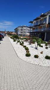 un trottoir avec des plantes à côté d'un bâtiment dans l'établissement APARTAMENT BLUE , Marynarska 8 , Sarbinowo, à Sarbinowo