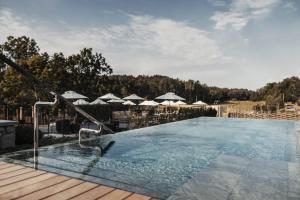 una piscina con sombrillas en una terraza de madera en Smådalarö Gård Hotell & Spa en Dalarö