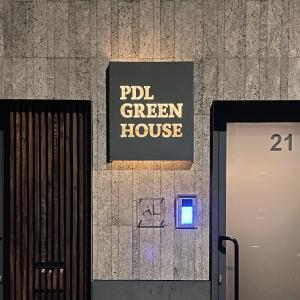 een bord op de muur van een groen huis bij PDL Green House in Ponta Delgada