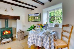 a dining room with a table and a fireplace at Mill House Cottage in Morpeth