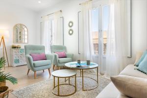 sala de estar con 2 sillas y mesa en Genteel Home Juan Rabadán en Sevilla