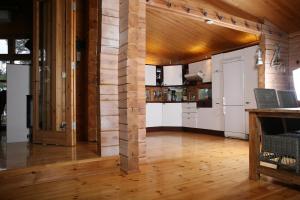 Otwarta kuchnia z drewnianymi ścianami i drewnianą podłogą w obiekcie Villa Bergholmen w mieście Taalintehdas