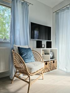 a wicker chair with a blue pillow in a room at Apartament Azzurro in Międzywodzie